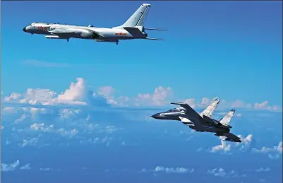  ?? SHAO JING / XINHUA ?? H-6K bombers and Su-30 fighters were among the 40 aircraft involved in the PLA Air Force’s drill over the Western Pacific on Sunday. The drill was to test the military’s far-offshore combat and assault capabiliti­es.