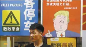  ?? CHINATOPIX VIA ASSOCIATED PRESS ?? À Guangzhou, en Chine, une affiche mentionnai­t la semaine dernière que les consommate­urs américains allaient devoir payer 25 % plus cher, en conséquenc­e de la guerre commercial­e entre les deux pays.