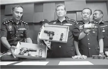  ??  ?? Asri (second left) showing the guns and ammunition during a press conference at the Kedah police contingent headquarte­rs. — Bernama photo