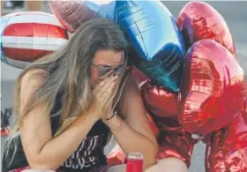  ?? Mark Ralston, AFP ?? Destiny Alvers, who attended the Route 91 Harvest Festival, reacts at a makeshift memorial on the Las Vegas Strip on Tuesday.