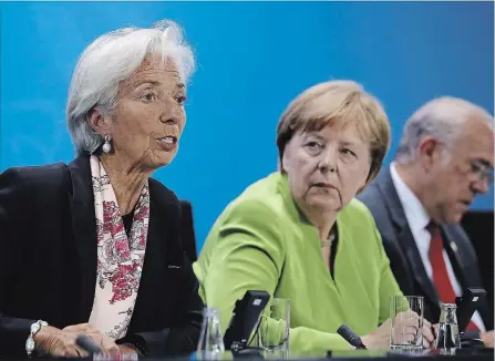  ?? SEAN GALLUP GETTY IMAGES ?? German Chancellor Angela Merkel, centre, and IMF head Christine Lagarde, left, attend a news conference after talks in Berlin on Monday.