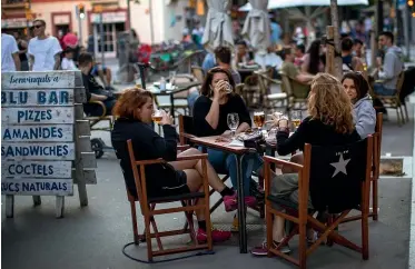  ?? AP ?? People drink as they sit on a terrace in Barcelona on the first day of a relaxation of lockdown rules for parts of Spain.