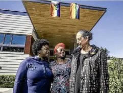  ?? ROBERT KITCHIN/STUFF ?? US embassy staffer Autumn Jackson and wife Deneen Jackson and Georgina Beyer at the embassy in Wellington, which has chosen to fly two gay pride flags.