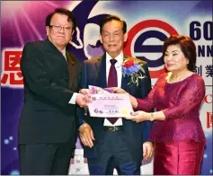  ??  ?? Albert Lau (left) who has served for 41 years receives his long service award from Su Kouk (centre) and wife Puan Sri Datin Wong Bak Hee.