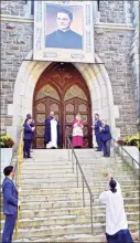  ??  ?? Bishop John Barres holds a relic of the Rev. Michael McGivney and stands under a portrait of McGivney at the door to St. Mary’s Church in New Haven on Saturday. The church held a Beatificat­ion Mass as McGivney, founder of the Knights of Columbus, moved a step closer to becoming a saint.