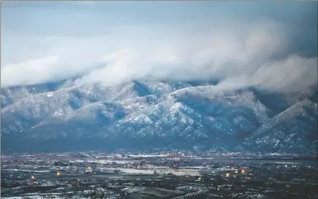  ?? MORGAN TIMMS/Taos News ?? A snow storm passes over the Sangre de Cristo mountains on Monday evening (Jan. 25).