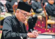  ?? AFP ?? PM Anwar Ibrahim signs documents after taking the oath during the swearing-in ceremony in Kuala Lumpur on Thursday.