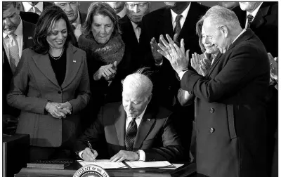  ?? SUSAN WALSH / ASSOCIATED PRESS FILE (2021) ?? President Joe Biden signs the $1.2 trillion bipartisan infrastruc­ture bill into law Nov. 15, 2021, during a ceremony on the South Lawn of the White House.