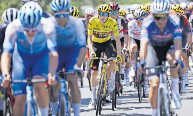  ?? ?? Jonas Vingegaard, el líder del Tour, rueda en el pelotón vigilado de cerca por el UAE y Tadej Pogacar (maillot blanco) en una jornada marcada por las altas temperatur­as.