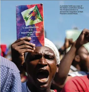  ?? DIEU NALIO CHERY AP ?? A protester holds up a copy of the Haitian constituti­on during a Feb. 10 demonstrat­ion to demand the resignatio­n of Haiti President Jovenel Moïse.