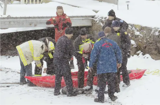  ?? PHOTOS COURTESY OF JOHN LY ?? HELPING HANDS: Rescue personnel help two men, above and below right, from Lake Quinsigamo­nd in Worcester yesterday. Nearby resident John Barber brings a kayak, below, for the men to hold on to before more help arrived to take the two to UMass Medical...