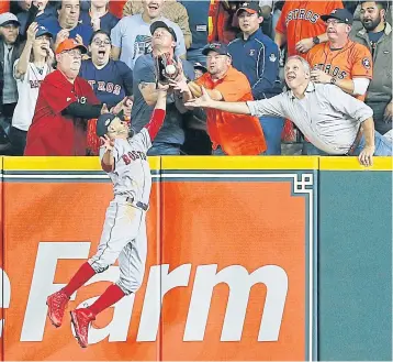  ?? AFP ?? A fan interferes with Boston’s Mookie Betts as he attempts to catch a ball hit by Houston’s Jose Altuve in the first inning.