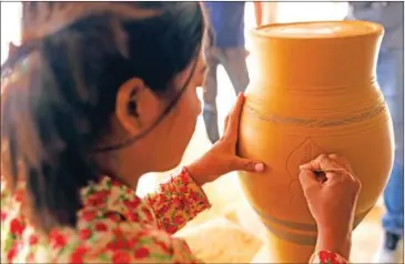  ?? HONG MENEA ?? A women engraves a traditiona­l pot in Kampong Chhnang province.