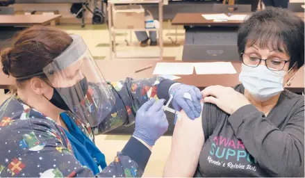  ?? MATT JONES/THE DAILY INDEPENDEN­T ?? Leslie Boardman, a nurse at the Greenup County Health Department, vaccinates Lois Cool on Tuesday in Greenup, Kentucky. Cool received the vaccine as part of the rollout for those 70 and older in the state.