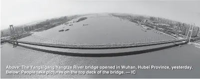  ??  ?? Above: The Yangsigang Yangtze River bridge opened in Wuhan, Hubei Province, yesterday. Below: People take pictures on the top deck of the bridge. — IC