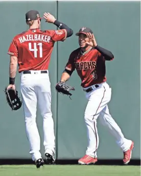  ?? DARRON CUMMINGS/AP ?? Diamondbac­ks outfielder Gregor Blanco is congratula­ted by Jeremy Hazelbaker after Blanco made a catch during a spring training game on March 7. Blanco and Hazelbaker are battling for one of the Diamondbac­ks’ final roster spots.