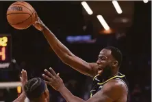  ?? Photos by Scott Strazzante / The Chronicle ?? Draymond Green passes over Heat guard Jimmy Butler in the first quarter of the Warriors’ 115-108 win over Miami.