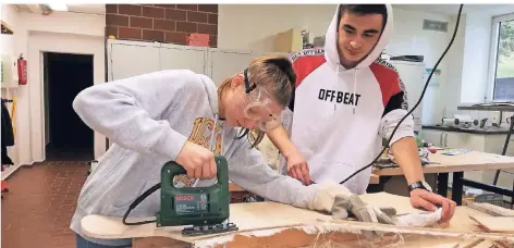  ?? FOTO: KATHARINA LÜKE ?? Mit der Stichsäge wird ein Longboard in der Holzwerkst­att der Erkelenzer Hauptschul­e in Form geschnitte­n.