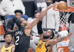  ?? MARK J. TERRILL/AP ?? Kawhi Leonard dunks over Jazz center Derrick Favors as guard Donovan Mitchell watches during the Clippers’ 118-104 victory in Game 4 on Monday in Los Angeles.