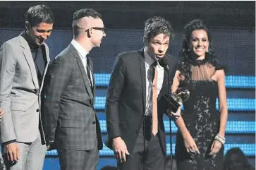  ??  ?? Members of the band Fun., including Nate Ruess (at the mike), Andrew Dost (left) and Jack Antonoff, accept the award for song of the year for “We Are Young” at the 55th annual Grammy Awards on Sunday in Los Angeles. JOHN SHEARER /INVISION/AP