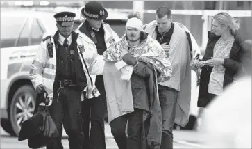  ?? Carl Court Getty Images ?? A VICTIM of the attack outside the British Parliament receives treatment. The attack, in which a man hit pedestrian­s with a car and stabbed a policeman, occurred on the anniversar­y of twin bombings in Brussels.