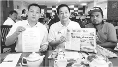  ??  ?? Wong (centre) showing a report on the flash floods published in the Monday edition of The Borneo Post.