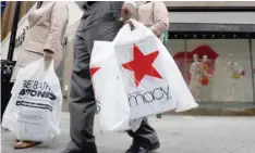  ?? — Reuters ?? A customer exits after shopping at a Macy’s store in the Brooklyn borough of New York.