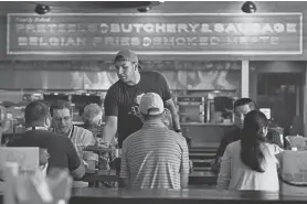  ?? MARK HUMPHREY/AP ?? David Rodriguez serves customers at Von Elrod’s Beer Hall and Kitchen in Nashville, Tenn. For the restaurant, located across the street from Nashville’s minor league baseball stadium that sees big crowds in the summer, both inflation and the worker shortage have sent costs skyrocketi­ng. Small businesses that depend on summer crowds and tourism are hoping for a bustling summer this year, boosted by pent-up demand after more than two years of the pandemic.