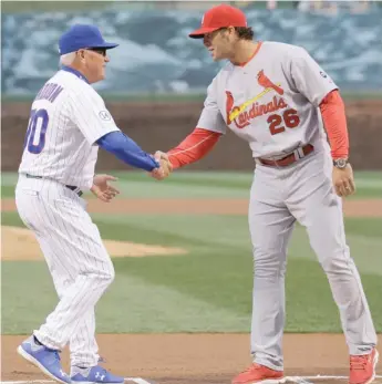  ?? AP ?? Joe Maddon shakes hands in 2015 with Mike Matheny, who was fired by the Cardinals on Saturday.