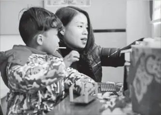  ?? MARK SCHIEFELBE­IN THE ASSOCIATED PRESS ?? Deng Guilian, wife of Chinese labor activist Hua Haifeng, plays with building blocks with their son Bo Bo, 4, in their home on the outskirts of Xiangyang.