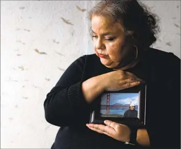  ?? Francine Orr Los Angeles Times ?? SANDRA MUÑOZ, a civil rights attorney in L.A., holds a photo of her husband, Luis Acensio Cordero, who was denied a visa to return to the U.S. from El Salvador, in part because of his tattoos.