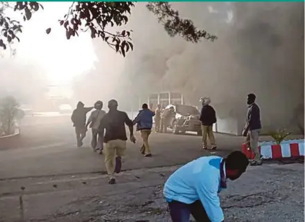  ??  ?? People reacting as a building burns in Wamena, Papua, yesterday.