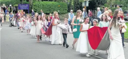  ??  ?? ●● The Rose Queen procession leaves Prestbury School with Rose Queen Julia Trier (front) followed by Rosebud Maggie Humphreys behind in her ceremonial cloak