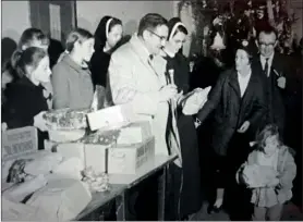  ??  ?? Jack Clancy and Nell Dineen (Red Cross, Mitchelsto­wn branch), handing out gifts to the children in Kilworth Camp on Christmas Day, 1970.