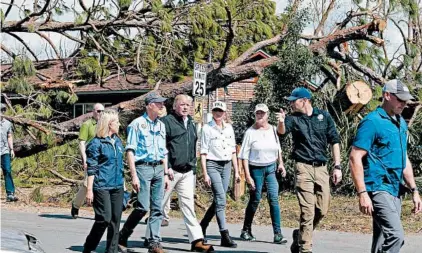  ?? MICHAEL SNYDER/NORTHWEST FLORIDA DAILY NEWS ?? Gov. Rick Scott, second from left, President Trump, first lady Melania Trump and Lynn Haven, Mayor Margo Anderson tour a devastated city neighborho­od Monday.