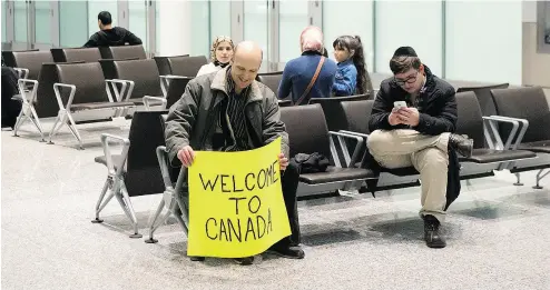  ?? CHRIS YOUNG / THE CANADIAN PRESS FILES ?? Well-wishers gather in the hope of greeting Syrian refugees at Toronto’s Pearson Airport in December.