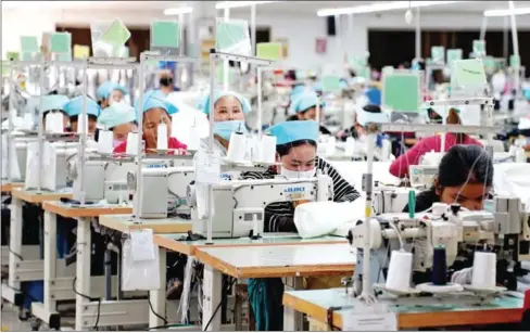  ?? YOUSOS APDOULRASH­IM ?? Garment workers at their sewing machines in a factory in Kandal province’s Ang Snoul district on January 20.