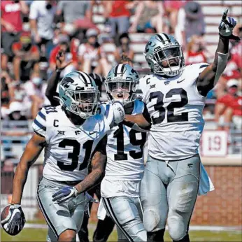  ?? SUE OGROCKI/AP ?? Kansas State’s Jahron McPherson (31) celebrates with teammates after an intercepti­on to seal the win Saturday.