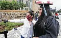  ?? Bob Owen / Staff photograph­er ?? Mariela Lopez, left, directs Lorena Garcia to have her picture taken at graduation on May 15 at Texas A&M-San Antonio.