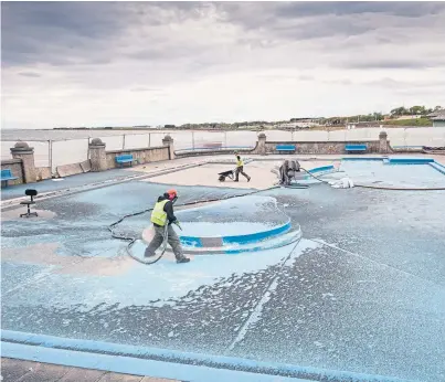 ?? Picture: Paul Reid. ?? Workers sandblast the old painted surface away at Arbroath paddling pool.