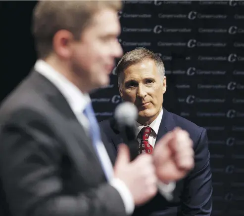  ?? IAN KUCERAK / POSTMEDIA NEWS FILES ?? Maxime Bernier listens to Andrew Scheer during the Conservati­ve leadership debate in February 2017. Bernier’s accusation that Scheer signed up thousands of “fake” voters caused blowback within the party caucus this week.