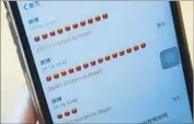  ?? AFP/ Getty I mages ?? A WOMAN in Beijing holds her phone after trying to post a candle emoji, which was targeted by censors.