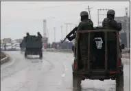  ?? AP/DAR YASIN ?? Indian troops patrol Thursday near the site of an attack on an Indian paramilita­ry convey in Pampore, Kashmir, that killed nearly three dozen soldiers.