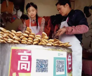  ??  ?? November 3, 2016: A Chinese oven rolls stand in Nanjing introduces mobile payment. CFP