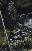  ?? KENT PORTER — THE PRESS DEMOCRAT VIA AP ?? Bodega Bay firefighte­rs work to secure the scene of a crash after a vehicle plummeted from the Bodega Head parking lot in Bodega Bay through a wood barrier, left, landing upside down 100 feet to the rocky shoreline, killing two people in the SUV on April 3.