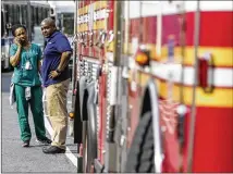  ?? JEENAH MOON / NEW YORK TIMES ?? Evacuees from the BronxLeban­on Hospital Center in New York wait during the Friday shooting incident. The shooter, Dr. Henry Bello, wounded six people and killed a doctor before turning his assault rifle on himself.