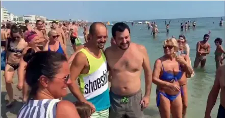  ??  ?? A bare-chested Matteo Salvini poses with beach goers as he rushes to exploit soaring public approval.