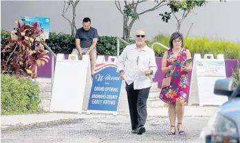  ?? MIKE STOCKER/STAFF PHOTOGRAPH­ER ?? Bruce MacBain and his sister Mila MacBain walk out of the polling precinct at ArtServe in Fort Lauderdale on Saturday. Bruce was taking advantage of early voting.