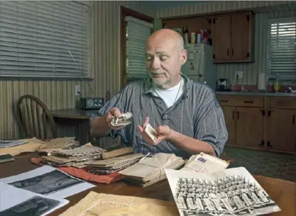  ?? Post-Gazette photo ?? David Wassel, an attorney who lives in White Oak, looks at letters Harry Dininger sent to his mother, Grace Dininger, while he was serving in the Pacific Theater during World War II. See more photos online at post-gazette.com