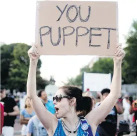  ?? ANDREW HARNIK / THE ASSOCIATED PRESS ?? A woman holds a sign that reads “You Puppet” during a demonstrat­ion outside the White House to protest President Donald Trump’s meetings in Helsinki with Russian President Vladimir Putin.